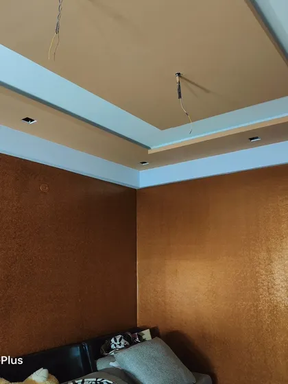This photo shows how the textured walls work with the room's two-level false ceiling design. The lighting highlights the texture, adding depth and visual interest.