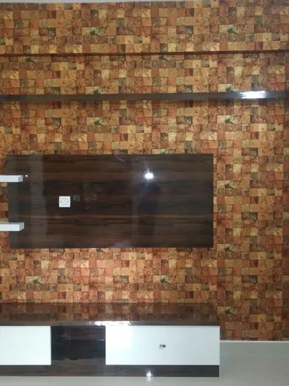 A textured, block-patterned wallpaper in warm earth tones installed around a media unit, creating a rustic and modern look.