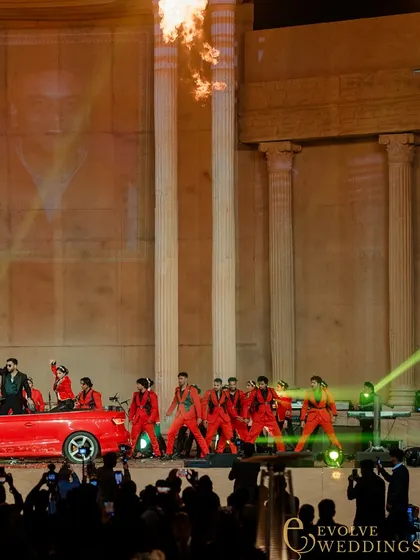 A dynamic performance featuring a red sports car on the grand stage, highlighting the production's capacity for spectacular entertainment.
