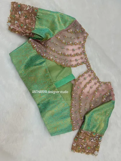 A beautiful sea-green and pink blouse with unique scalloped net detailing on the back.
