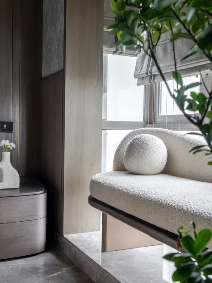 A favorite bay window nook, featuring a custom-designed chaise lounge with soft, boucle fabric. It's the perfect spot to curl up with a book and enjoy the city view.