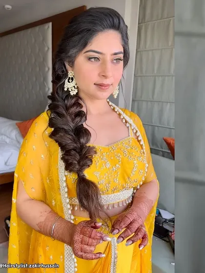 Another view of the side-swept fishtail braid, showing how it drapes elegantly over the shoulder. This style is perfect for showcasing a beautiful backless blouse.