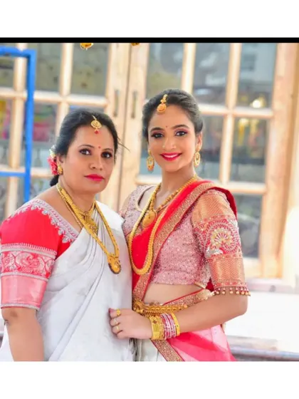 For this mother-daughter pair, we focused on coordinating through exquisite blouse craftsmanship. The daughter's sheer puff-sleeve blouse is adorned with intricate zardosi work, echoing the traditional elegance of her mother's silk saree and custom-stitched blouse.