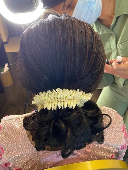 A behind-the-scenes look at me perfecting a sleek bridal bun, ensuring every strand is in place.