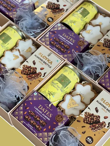 A close-up of the delicious treats packed in our Diwali hampers. This assortment includes caramel almond dates, almond brittle, and star-shaped cookies, offering a delightful mix of flavors.