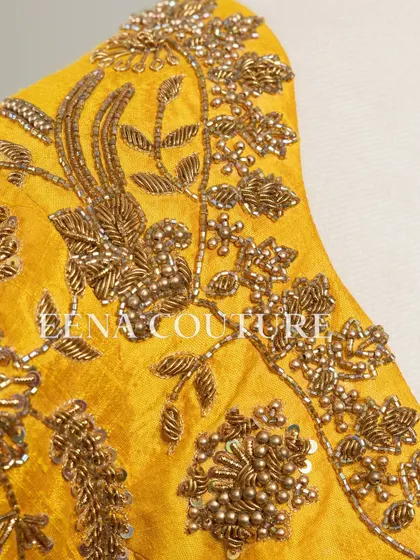 This sunshine yellow raw silk blouse is brought to life with meticulous hand embroidery by my talented artisans. The dense, traditional motifs in antique gold threadwork cover the back and sleeves, creating a piece that radiates warmth and luxury.