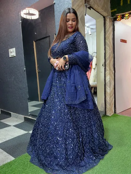 A full-length shot of the navy blue sequin lehenga, showing its beautiful flare and sparkle.