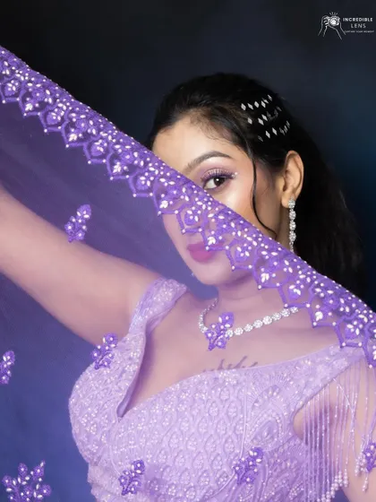 A playful shot peeking through the dupatta. The eye makeup is the star of the show, with a pop of purple and glitter.
