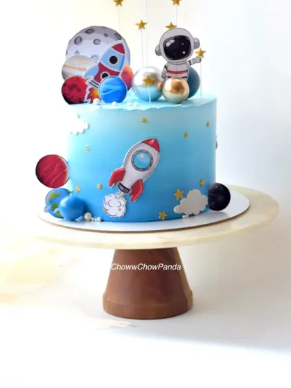 An out-of-this-world space theme cake. This Oreo Cream o Cookie cake is decorated with planets, rockets, and an astronaut, perfect for a budding space explorer.