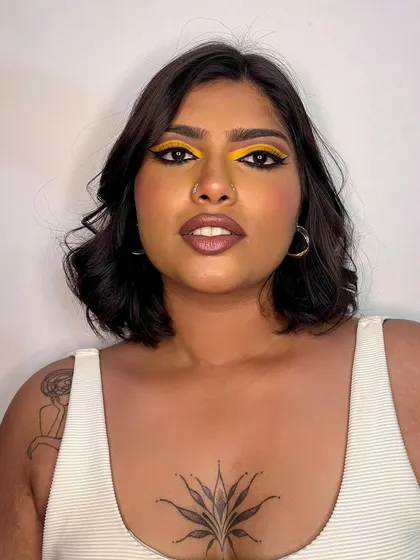 A direct-to-camera shot of the yellow graphic liner look. The sharp wings and bold color make a powerful statement.
