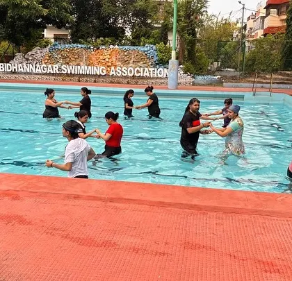 The group holds hands and moves together in the water, showcasing the fun and social aspect of my aqua fitness classes.