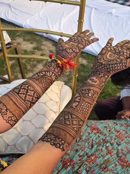 A close-up of a guest's mehandi, showing how we can create beautiful and detailed designs for the whole family. This pattern includes the guest's name, 'Anu', hidden in the design.