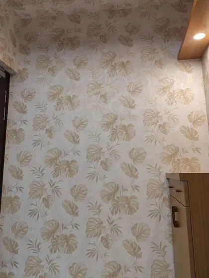 A hallway or entryway featuring a light-colored wallpaper with a monstera leaf pattern. It's a great way to welcome guests with a touch of modern style.