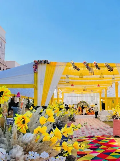 A side view of the grand yellow and white tent for a Haldi ceremony, showing how we transform large outdoor spaces into beautiful event venues.
