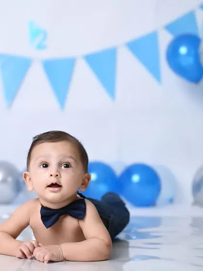 A curious little explorer at his 6-month photoshoot, with a simple and clean blue-themed setup.