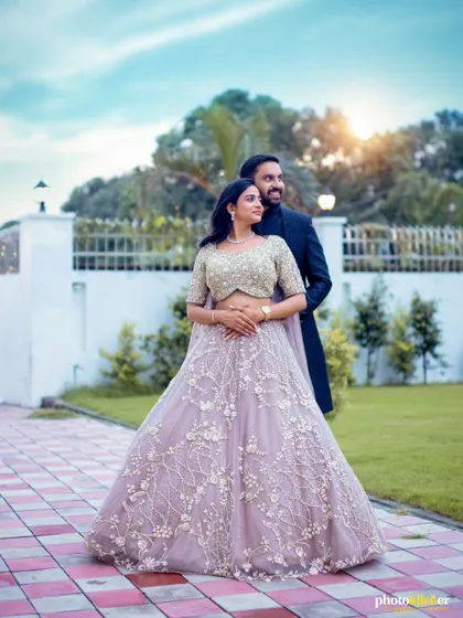 A classic, elegant portrait of a couple in their ring ceremony attire, posing in a beautifully landscaped garden.
