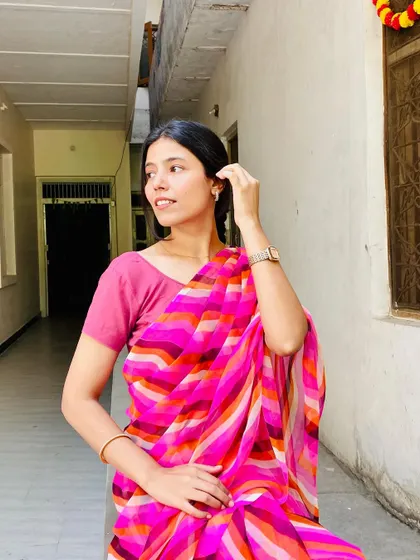 Modeling a colorful, striped georgette saree, this image presents a simple and elegant look for everyday or office wear.