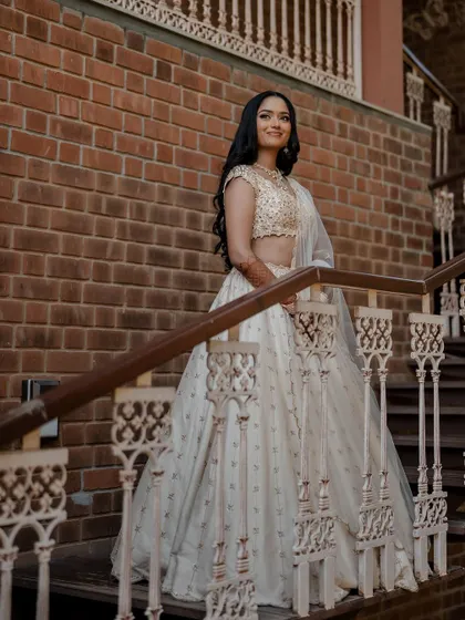 A stunning bride in a white lehenga, exuding grace and elegance. We use creative framing and lighting to capture a variety of beautiful portraits.