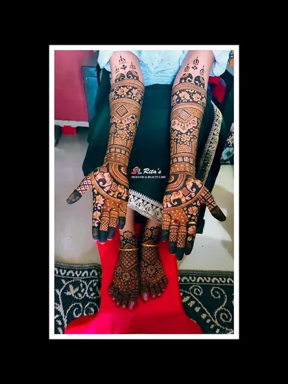 The complete bridal mehendi for a South Indian wedding, with coordinated designs on the hands and feet. The patterns are intricate and full, perfect for a bride.