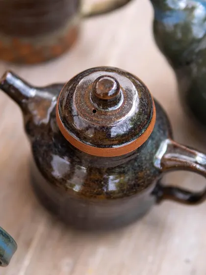An overhead view of a teapot, highlighting the perfect fit of the lid and the rich texture of the glaze. Attention to detail is a key focus in our specialized courses.