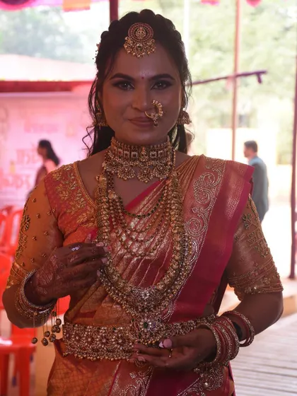A close-up of the bride's stunning jewelry and the neat shoulder pleats of her pre-pleated saree.