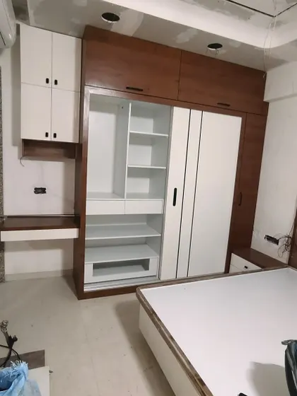 A work-in-progress shot of a bedroom, showing a sliding wardrobe with an attached study table and overhead cabinets. This is a great example of my multi-functional furniture design.