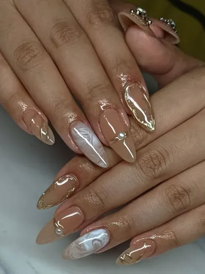 This neutral set is anything but boring. We combined a creamy nude base with a white marble accent nail and sculpted gold chrome details.
