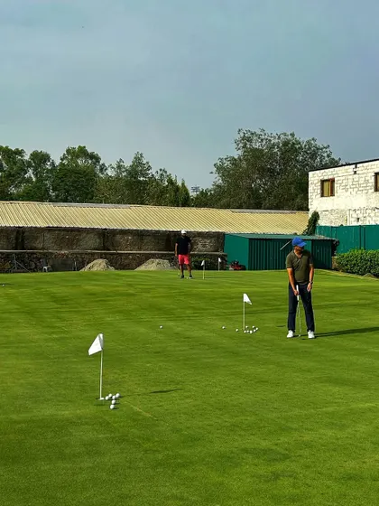The putting green is dotted with golfers working on their short game. This is where scores are lowered.