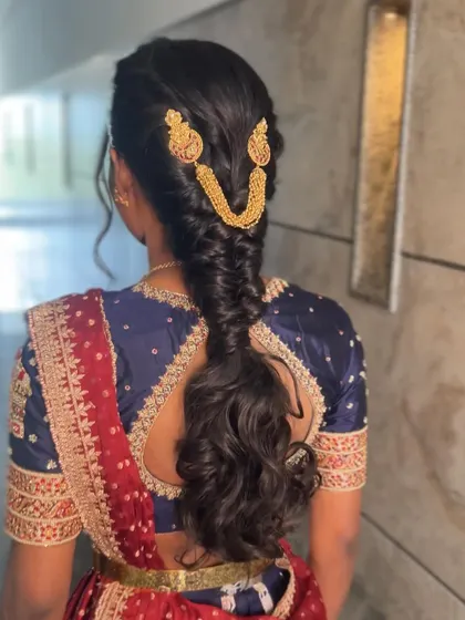 A modern take on a bridal braid, with a looser, more romantic feel and a curly, open end. This style is perfect for a reception or sangeet.