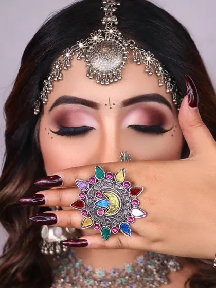 A creative shot focusing on the dramatic eye makeup and the colorful, oversized ring that defines the boho aesthetic.