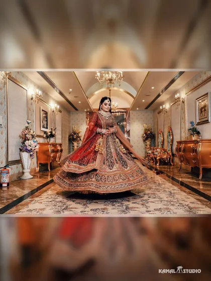 A stunning shot of the bride twirling in her heavily embroidered lehenga in a grand, ornate hallway.