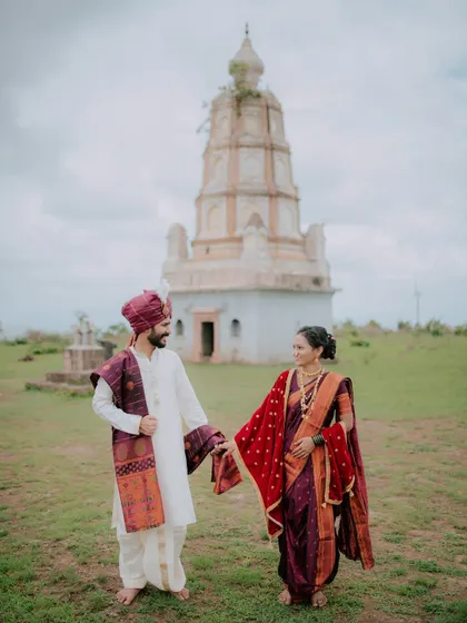 A couple holding hands in front of an ancient temple, blending their love story with heritage.