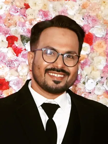 A portrait against a floral backdrop. The groom's makeup is balanced to look good in photos, ensuring he looks his best in every memory captured.