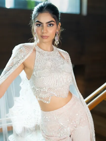 A closer look at the exquisite detailing on this Mishru outfit. The combination of the halter top and cape creates a look that is both elegant and on-trend for the modern bridesmaid.