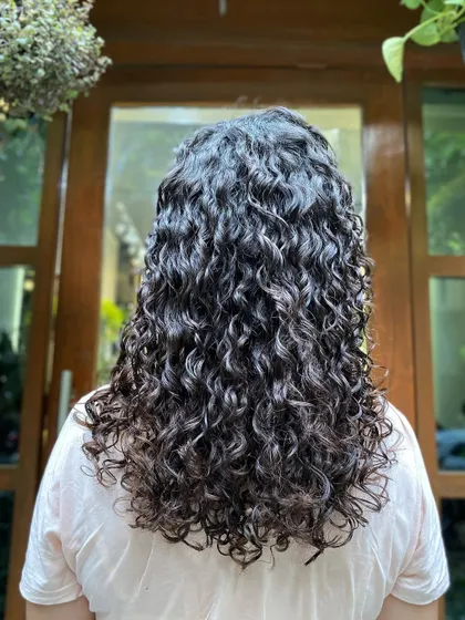 This client from France came in with dry, undefined curls. After a deep conditioning treatment and a precision haircut, her hair was revitalized, hydrated, and full of life.