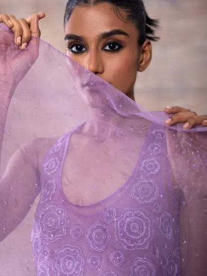 A mysterious and alluring shot for Akashi Clothing. The makeup is focused on the eyes, with a dark liner that draws attention even with part of the face veiled by the sheer purple fabric.