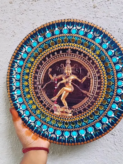 Holding the completed Nataraja dot mandala art. The piece is 12 inches in diameter and is ready to become a centerpiece in a home.