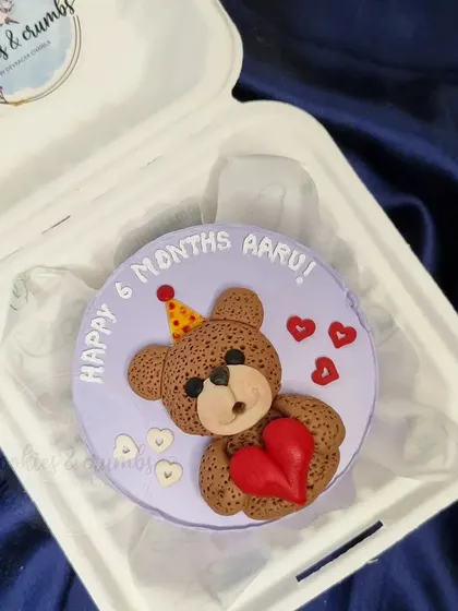 A sweet teddy bear bento cake for a 6-month celebration. The hand-molded fondant bear holding a heart is perfect for celebrating little milestones.