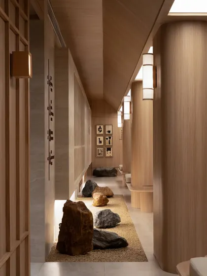 A meditative corridor at BeWell, where natural stones are arranged like a zen garden. This pathway is a sensory experience, with the interplay of light, shadow, and tactile materials guiding visitors on their wellness journey.