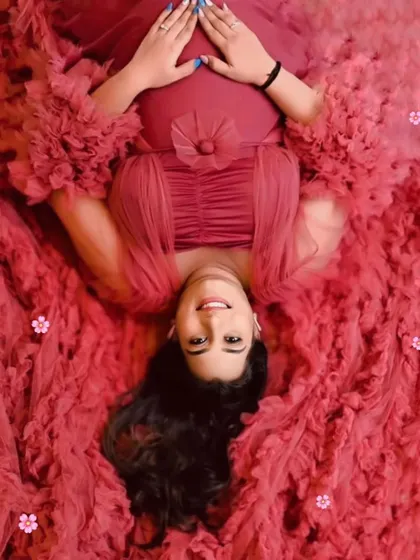 This creative overhead shot showcases the beautiful texture and volume of our wine-red ruffled gown, creating a bed of flowers effect.