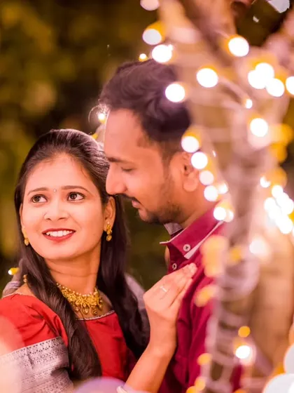 A candid shot of a couple sharing a loving glance, with the soft bokeh of fairy lights creating a magical frame around them.