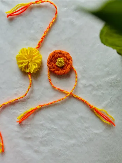 A close-up of my yellow and orange floral rakhis. These are crafted from soft knitted cord, making them comfortable to wear and a beautiful keepsake.