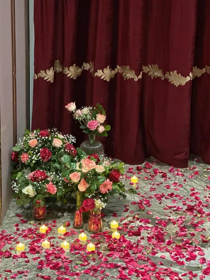 A beautiful arrangement of flower bouquets and candles on the floor, adding to the romantic and luxurious feel of the room decoration.