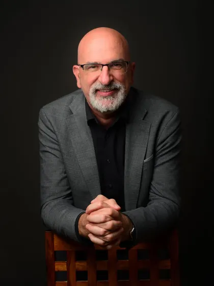 This seated portrait provides a direct and engaging look. It's an excellent choice for a website's 'About Us' page or a professional biography.