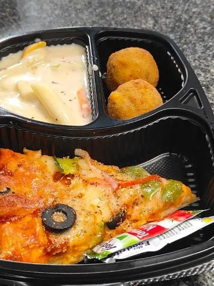 Mini pizza, pasta and round fried bites sit in separate compartments in this birthday party snack tray we put together.