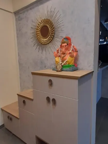 A compact pooja and storage unit with a Ganesha idol. The unit includes drawers and cabinets, making it a practical and spiritual corner of the home.