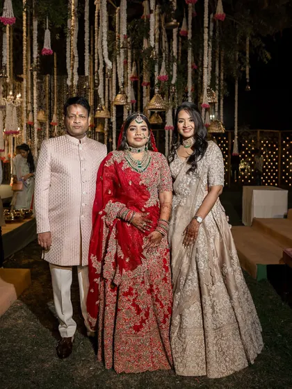 A family portrait of the bride with her father and sister, all styled by us for a cohesive and elegant wedding day look.