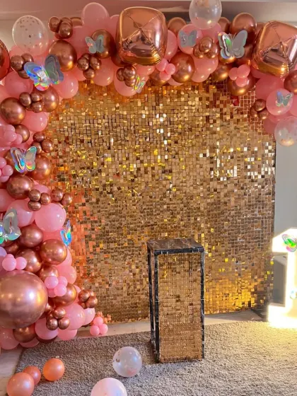 Another angle of the rose gold sequin backdrop, showing the full balloon arch and scattered floor balloons.
