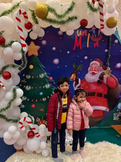 Siblings posing for a picture at our Christmas event, complete with candy canes and a cheerful Santa backdrop.