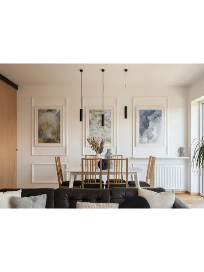A simple and clean dining setup. The minimalist table and chairs, paired with modern pendant lights and abstract art, create a contemporary and functional dining space.